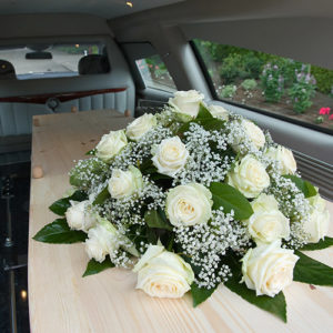coffin with floral display in back of Swindon Hearse
